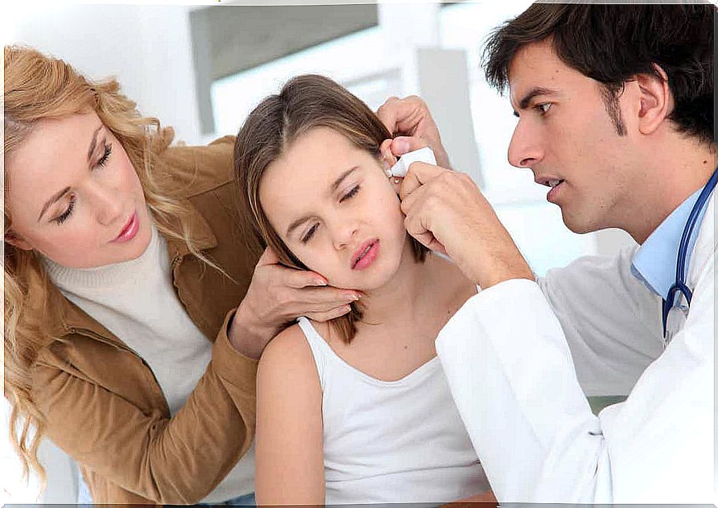 A pediatrician looking at a child's ear.