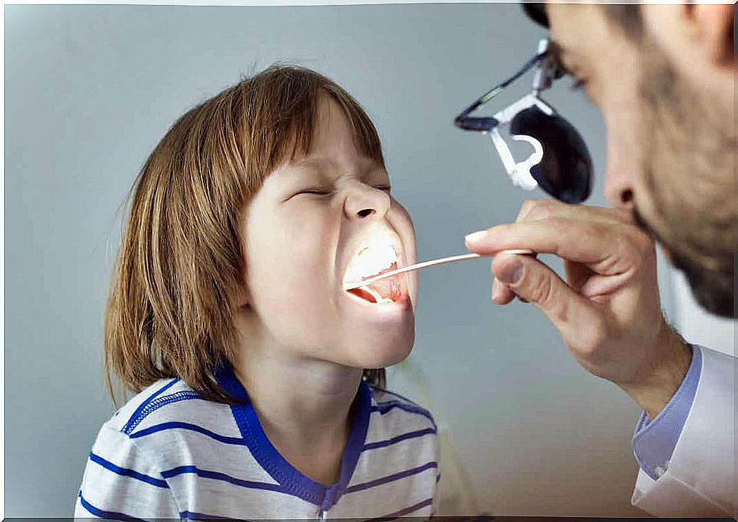 A pediatrician checking a child's throat.