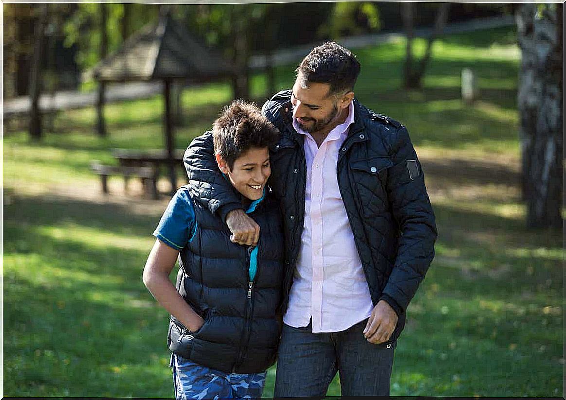 A father and son are walking through the park.