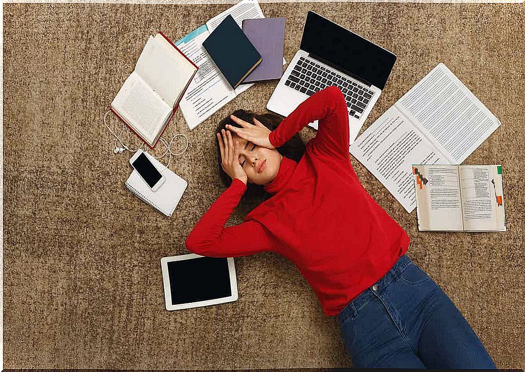 A youngster lying on the floor feeling overwhelmed by schoolwork.