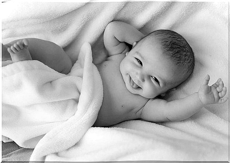 Laughing baby under a blanket