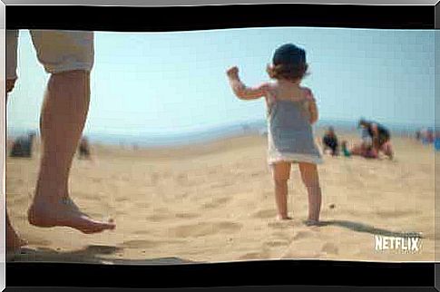 A scene from the Netflix docuseries where a baby walks on the beach.