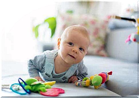 A baby lying head up on the floor.