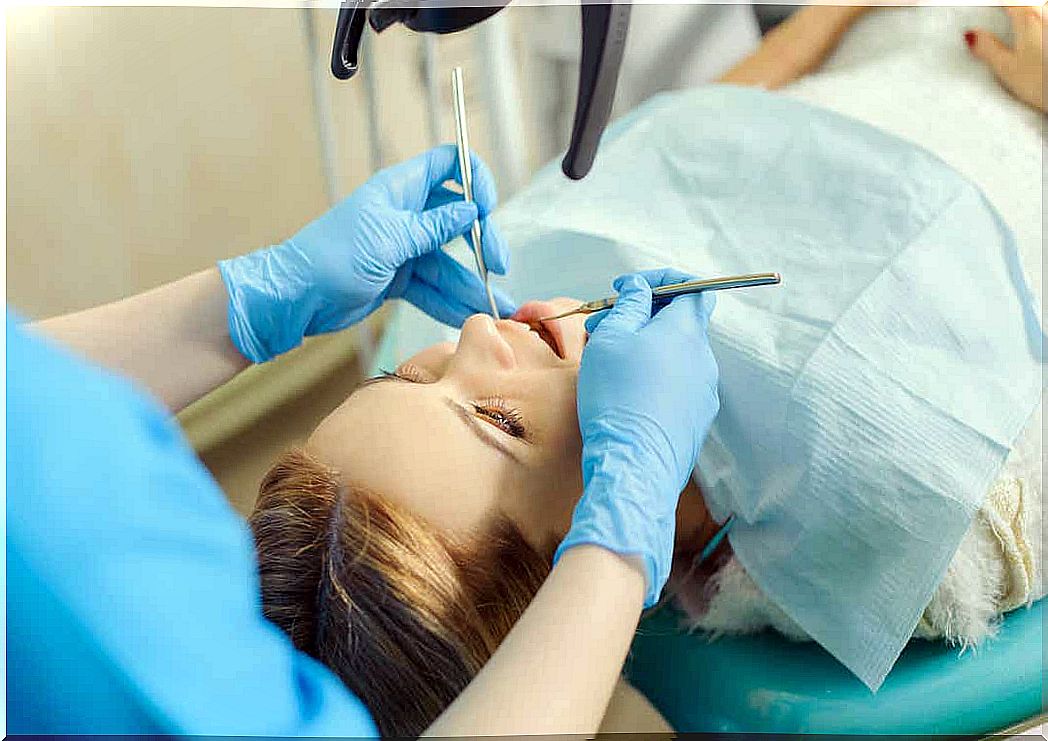 A dentist working on a woman's teeth.