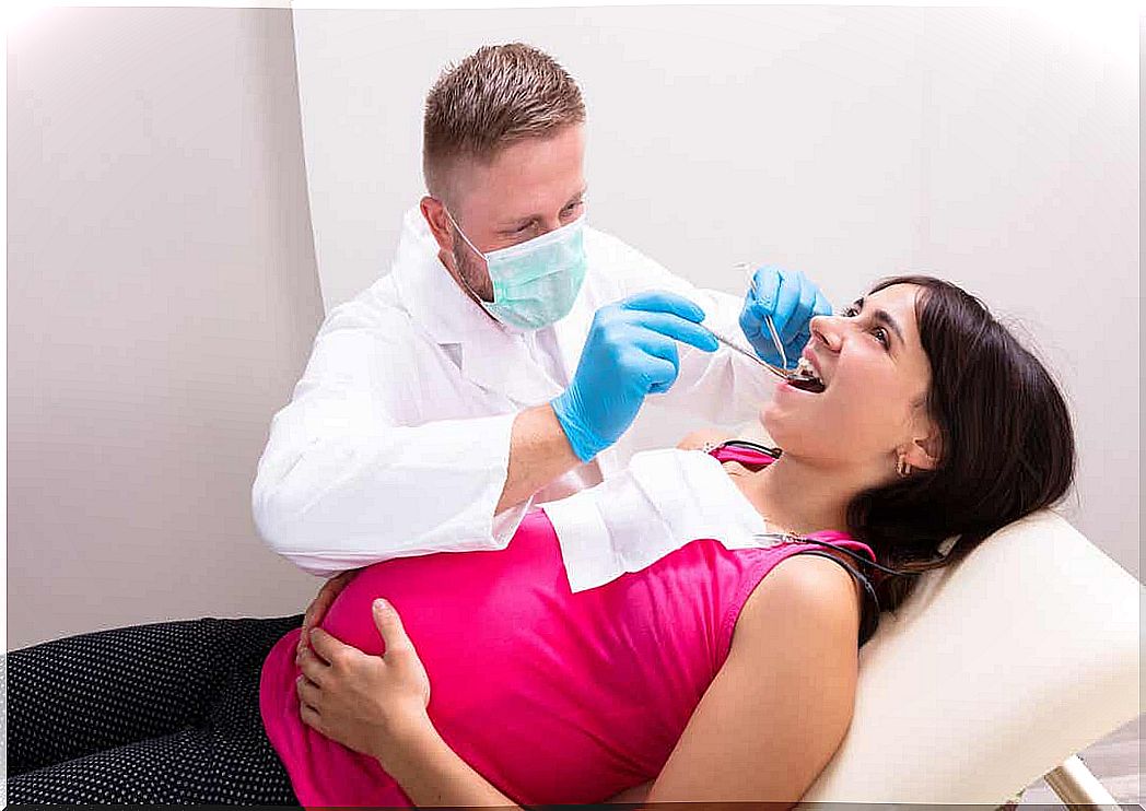 A dentist checking a pregnant woman's teeth.