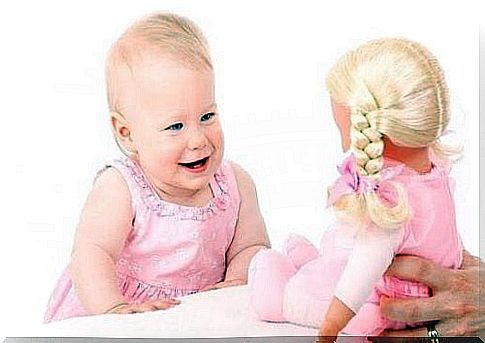 Learning to laugh: baby with doll