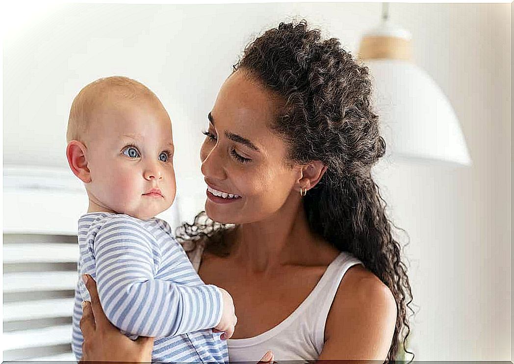 A mother smiles at her baby.