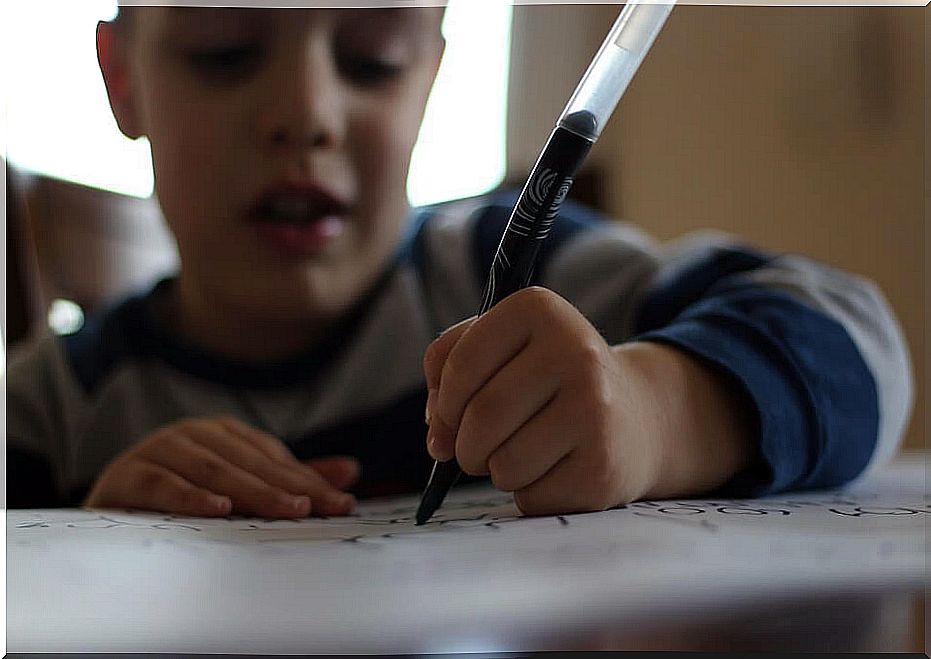 Child writes with a marker