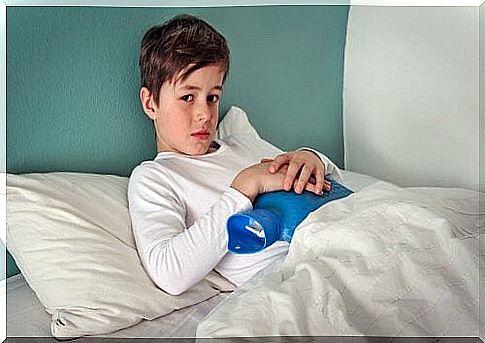 Little boy in bed with a hot water bottle on his stomach