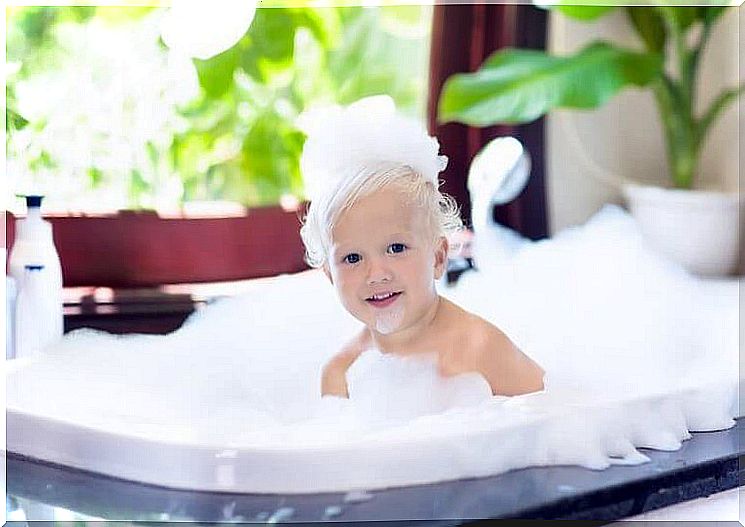 Baby is in the bath with a lot of bubble bath