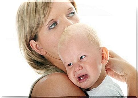 mother carries crying baby