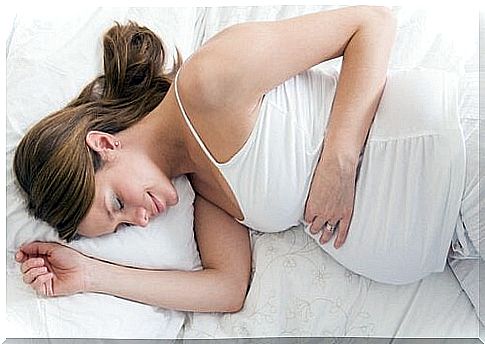 Pregnant woman is sleeping in bed