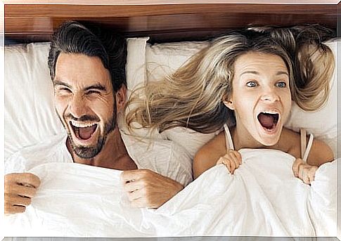 Couple lying in bed smiling