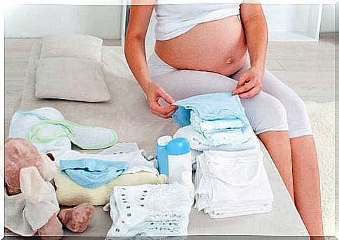 Pregnant woman with a pile of clothes