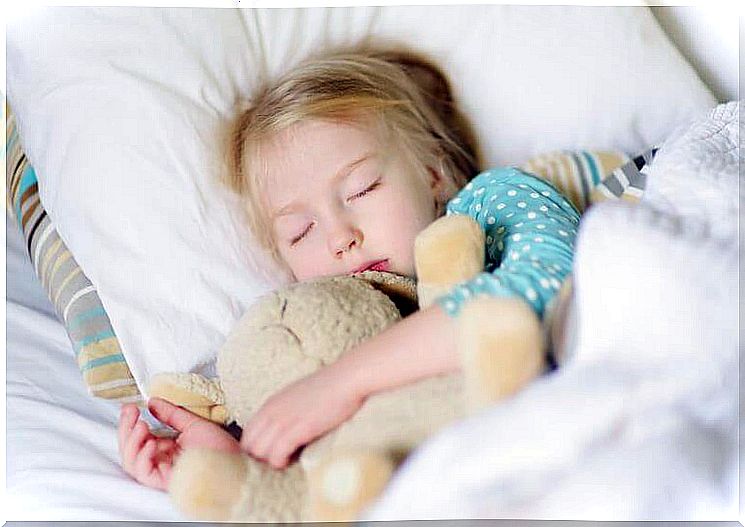 Child sleeps with a bear